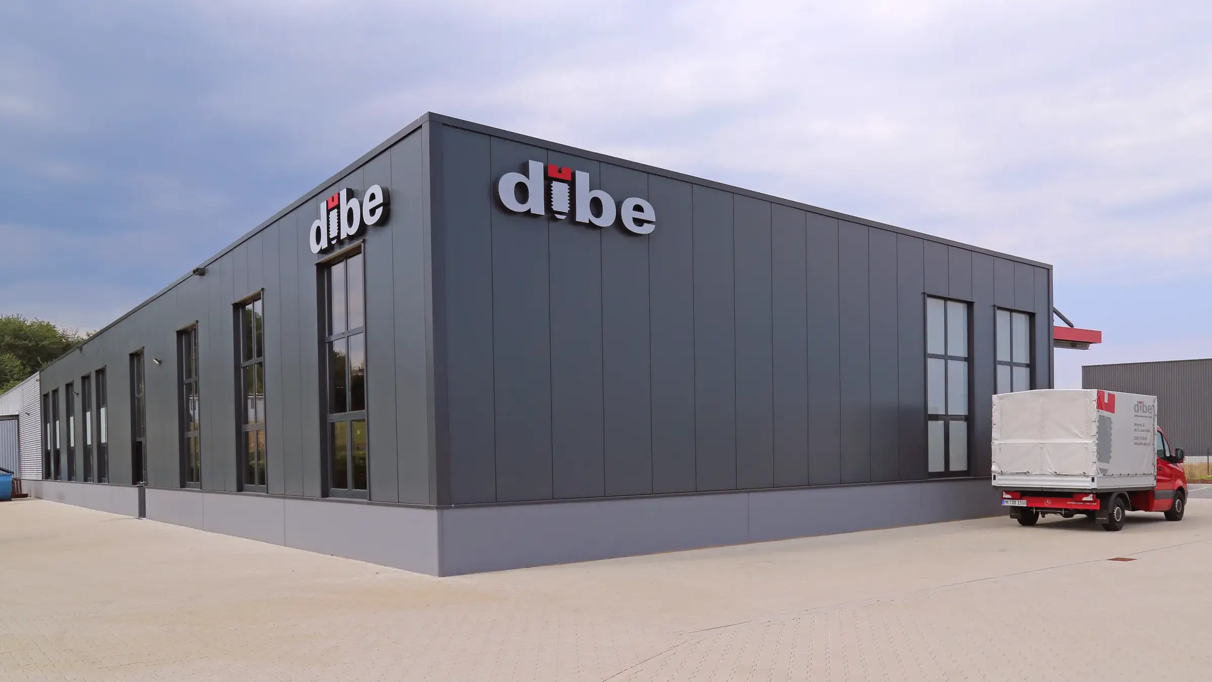 Betriebsneubau Dibe in Lüdenscheid: anthrazitfarbene Halle mit Schriftzug und Fensterbändern