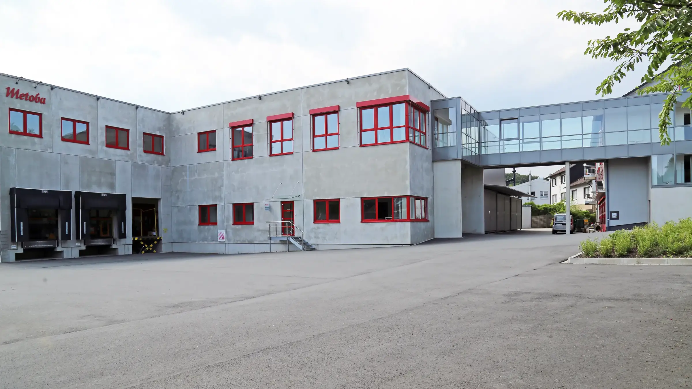 Lagerneubau Metoba in Lüdenscheid mit verglaster Verbindungsbrücke zum Bestand