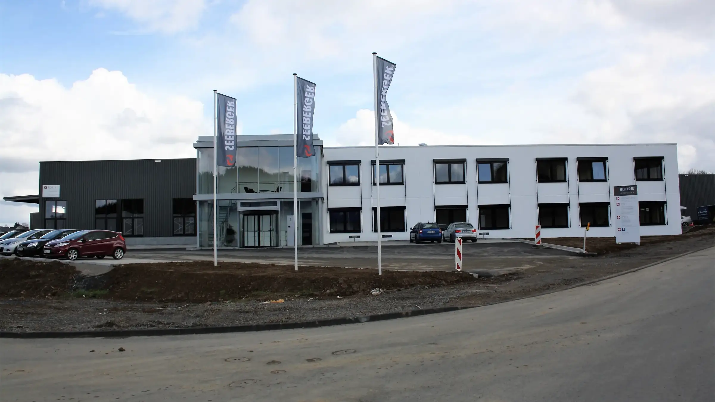 Betrieb Seeberger in Schalksmühle: dreigeschossiger Bürotrakt mit Fahnen vor der Halle